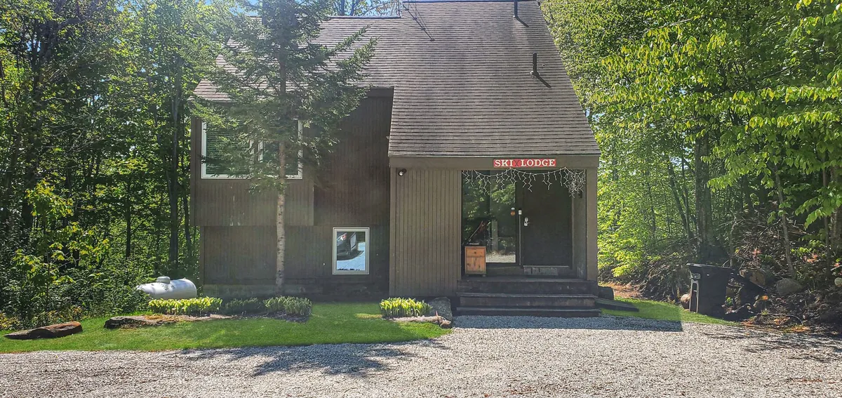 This exterior shot captures the ski lodge sign, the entrance steps leading up to the lodge, and a taste of the surrounding natural landscape. There’s a sense of anticipation and adventure, with subtle hints of both outdoor activity and a welcoming home base.